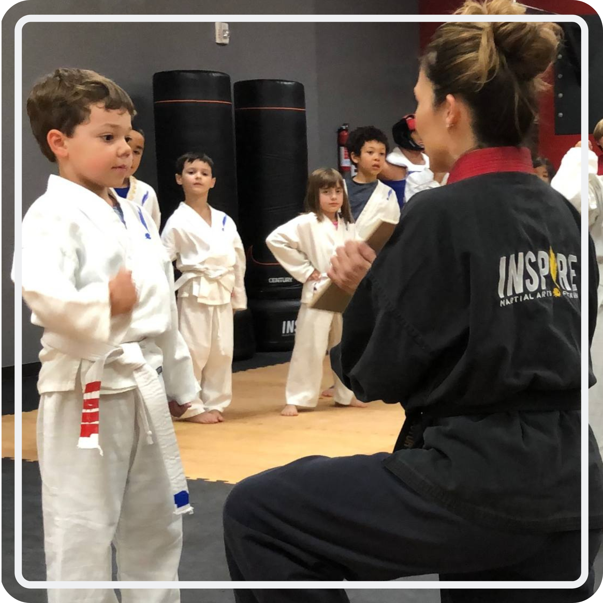 A young Mighty Bulldogs student practicing with an Inspire instructor holding a board